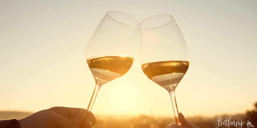 Two people clinking wine glasses on a sunny Las Vegas patio