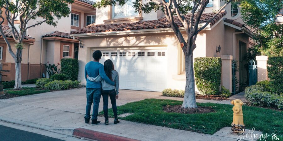 Couple touring a sunny home during a holiday weekend open house with a real estate agent