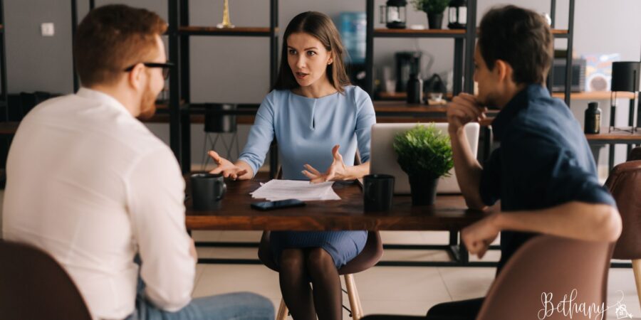 Real estate agent discussing home pricing strategy with homeowner at desk